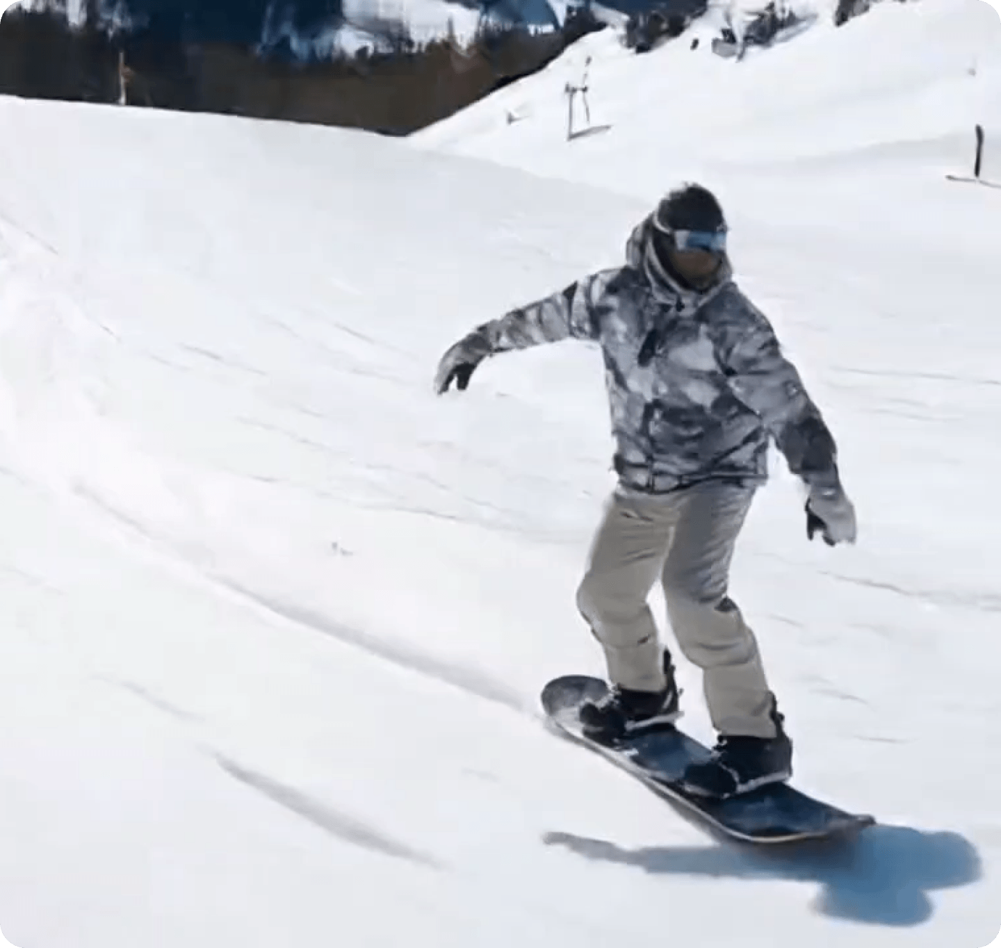 Snowboarder riding down a snowy slope